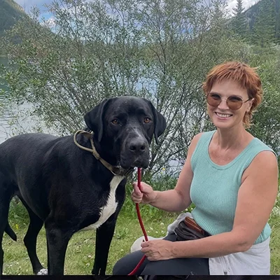 Tamara smiling outside with her dog.